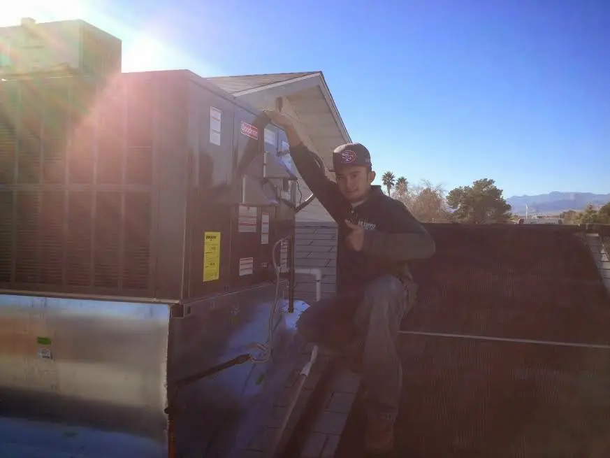 HVAC technician performing Boiler Repair on a rooftop unit in Carterville